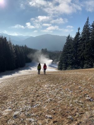 Zwei Frauen gehen im Morgennebel den Berg hinab